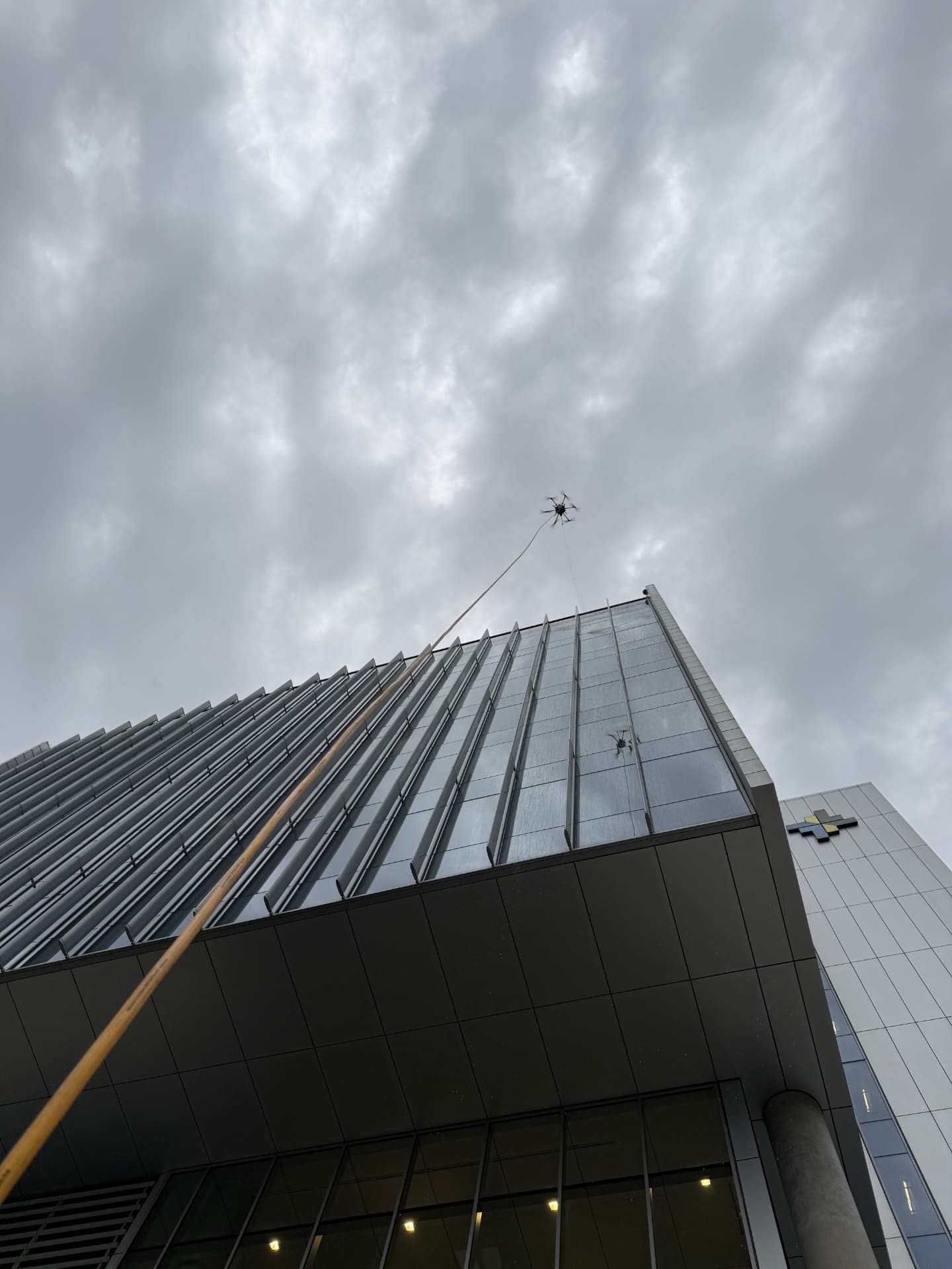 Drone above a metal and glass facade on an overcast day