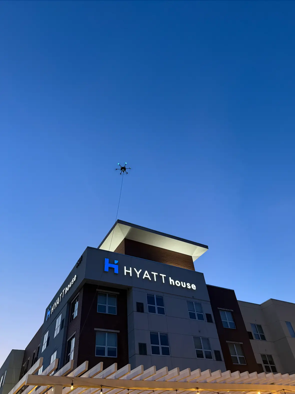 Drone working above a hotel building at twilight