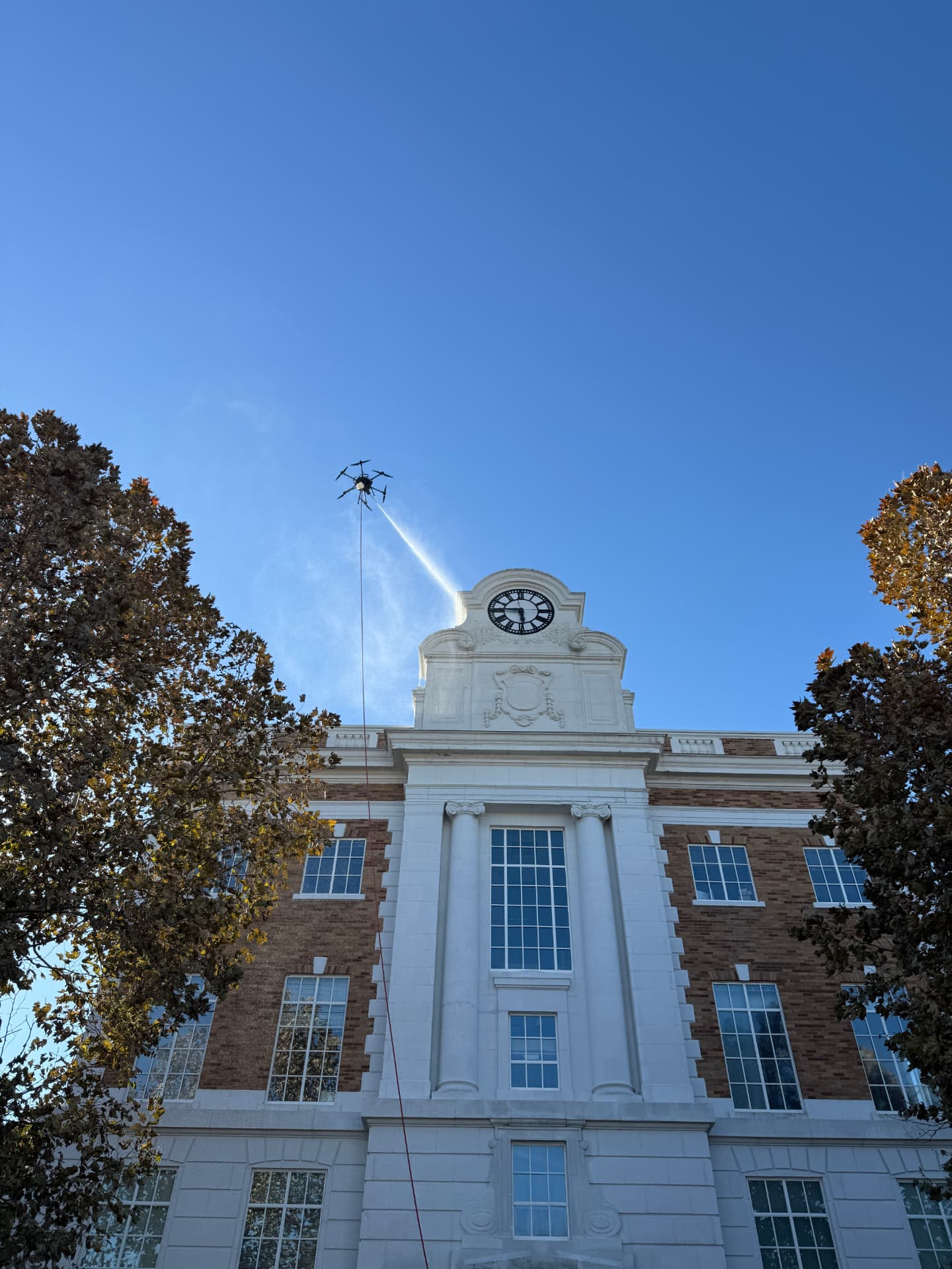 Drone rinsing the clock tower of a historic masonry building