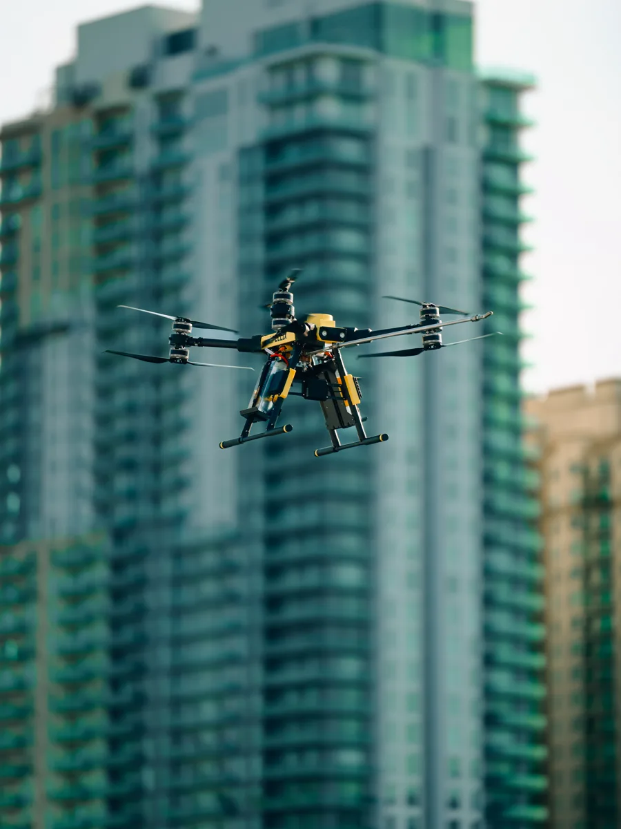 Commercial cleaning drone flying in front of a high-rise building